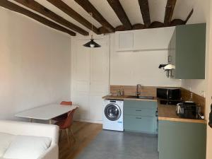a kitchen with a washer and dryer in a room at Le Sauge in Angers