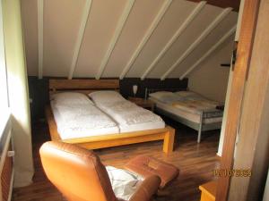 a attic room with two beds and a chair at Ferienwohnung,Über Tage in Bochum