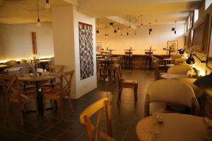 a restaurant with tables and chairs in a room at Hills Hotel in Karakol