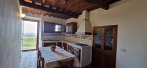 een keuken met een houten tafel en een tafel sidx sidx sidx bij Agriturismo La Rugiada di Pociano in Monteroni dʼArbia