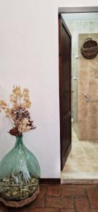 een vaas met bloemen erin naast een deur bij Agriturismo La Rugiada di Pociano in Monteroni dʼArbia