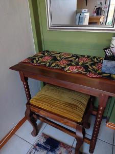 a table with a bench with a blanket on it at Fynbos Single Stay in Langebaan