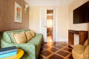 a living room with a green couch and a table at Casa Monti Roma in Rome