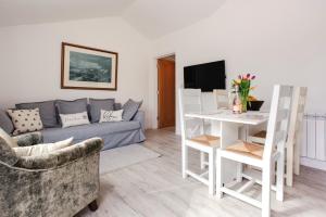 ein Wohnzimmer mit Sofa und Tisch in der Unterkunft Willow Cottage in Ryde