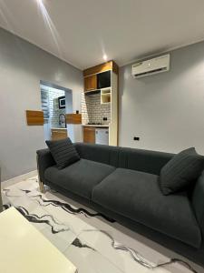 a living room with a black couch and a kitchen at Apartment 5 in Abuja +31 photos