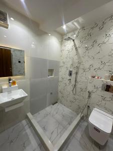 Un baño con ducha, inodoro y lavabo. en Apartment 5, en Abuja