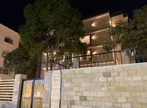 un bâtiment avec un mur et un arbre devant dans l'établissement Pyramids Spiritual Gate, au Caire