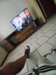 a person laying on the floor in front of a television at Caso 3 in São José