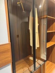 a closet with a glass door with a robe at Apartment 5 in Abuja