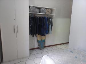 a room with a closet with a surfboard in it at Caso 3 in São José