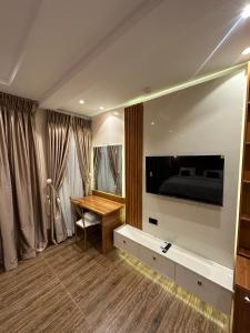 Habitación con escritorio, TV y cama. en Apartment 5, en Abuja 31 fotos más