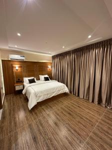 a bedroom with a large bed and curtains at Apartment 5 in Abuja