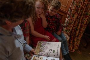 een groep kinderen die naar een boek kijken bij Sherramore Lodge in Laggan +22 foto's