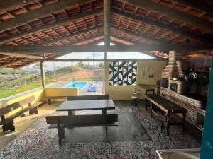 uma sala de estar com uma mesa e uma piscina em Solar Serra das Piteiras - Paivas - Pará de Minas, Minas Gerais em Pará de Minas