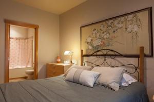 a bedroom with a bed with a painting on the wall at River Scene 30 Night Minimum in White Salmon