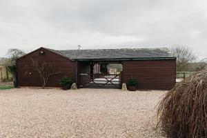 Eine Scheune mit offener Tür in einem Kieshof in der Unterkunft Willow Cottage in Ryde