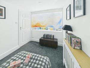 ein Schlafzimmer mit einem Bett und einem Tisch und einem Bett sidx sidx sidx in der Unterkunft Spacious light and airy apartment with Cinema room in Ottery Saint Mary