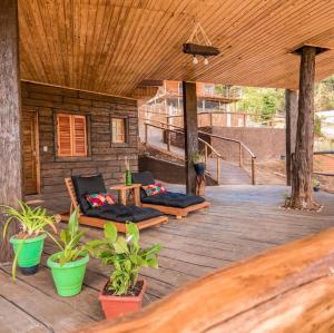 a porch of a house with chairs and plants at Hospedaria Sol & Lua in São Bento do Sapucaí