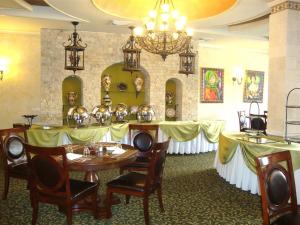 a dining room with tables and chairs and a chandelier at Hotel Gran Mediterraneo in San Pedro Sula