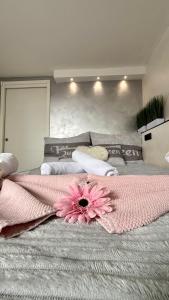 a bed with a pink flower on top of it at Apartment Sova or Deluxe room 33 in Bled