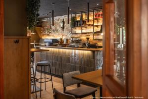 SitzenbergSmarthotel Schmid的带酒吧的餐厅，酒吧里有椅子和桌子