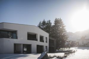 a white building with snow on the ground at Alpinhotel Keil in Valdaora