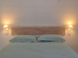 a bedroom with a bed with two pillows and two lights at Pousada Janela dos Ventos in Caucaia +8 photos