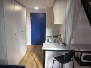 a kitchen with a sink and a blue door at Heart of Kaunas - Cozy Loft with Wi-Fi in Kaunas