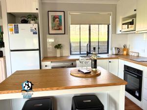 Lake & Reserve Front Bird Haven - 3BR في Encounter Bay: مطبخ مع كونتر عليه كؤوس للنبيذ