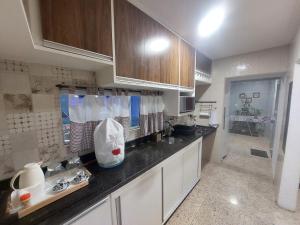 a kitchen with white cabinets and a black counter top at Casa de Arembepe in Camaçari