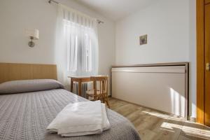 a bedroom with two beds and a table and a window at Alojamiento cristo rey in Pozuelo de Alarcón