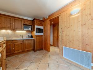 uma cozinha com armários de madeira e piso de cerâmica em Appartement chaleureux 4 pièces, 6 pers, terrasse sud, Méribel - FR-1-411-975 em Les Allues mais 8 fotografias