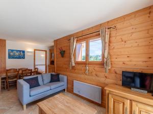 uma sala de estar com um sofá e uma televisão em Appartement chaleureux 4 pièces, 6 pers, terrasse sud, Méribel - FR-1-411-975 em Les Allues