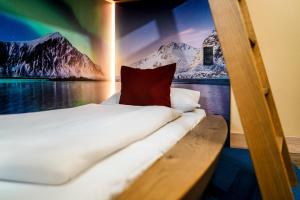 a bed on a boat with a painting on the wall at Ostseehotel Midgard in Damp in Damp