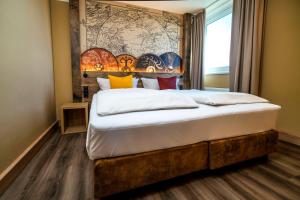 a bedroom with a large bed with a large headboard at Ostseehotel Midgard in Damp in Damp +44 photos
