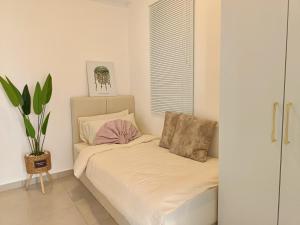 a bed in a room with a plant on it at KLIA Airport Xiamen Sepang WiFi Gym Pool 吉隆坡国际机场 厦门大学 in Kampong Bekoh +47 photos