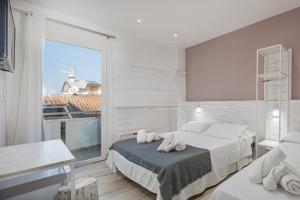 a bedroom with two beds and a large window at Evo Boutique Hotel & SPA in Bellaria-Igea Marina