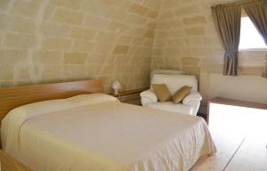 a bedroom with a bed and a chair and a window at Antica Dimora storica La finestra sul campanile in Matera