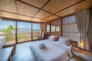 a bedroom with a large bed with a large window at Mizu Homes By Avanterra in Nusa Lembongan +121 photos