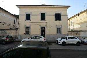 Dos coches estacionados en un estacionamiento frente a un edificio. en Le case di Emma, en Matera