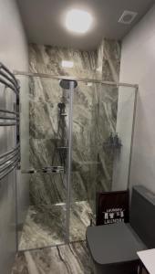 a bathroom with a glass shower with a toilet at DiAngelo Guesthouse in Yerevan