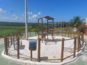 a playground in the water with a fence at Casa de Arembepe in Camaçari