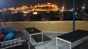 a balcony with a view of the city at night at Hotel akty Jaisalmer in Jaisalmer +3 photos