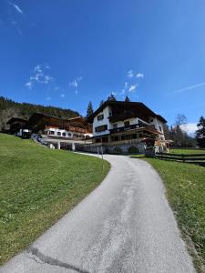 une route sinueuse devant une maison dans l'établissement Landhaus Tuxerschafer, à Tux