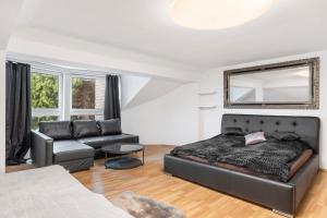 een slaapkamer met een bed en een bank bij Black Dragon Haven Villa with Pool Sauna Jacuzzi BBQ & Parking for 8 Cars in Praag