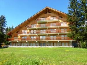 a large building with balconies and a grass field at Studio 4 pers. au pied des pistes à Méribel Altiport, animaux admis - FR-1-411-397 in Les Allues