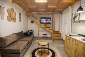 sala de estar con sofá y TV y cocina en Lalun, en Golem