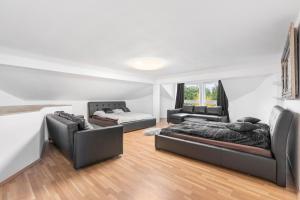a living room with two beds and a couch at Black Dragon Haven Luxury Villa with Pool, Sauna & Jacuzzi in Prague