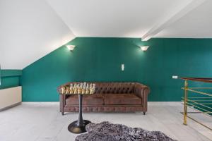 a couch in a room with a green wall at Black Dragon Haven in Prague +141 photos