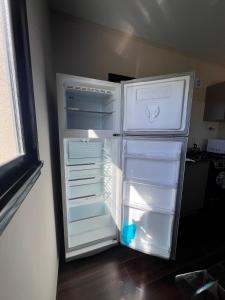 an empty refrigerator with its door open in a kitchen at Hospedaje a 2 cuadras del mar Mar de Cobo 4 personas in Mar de Cobo